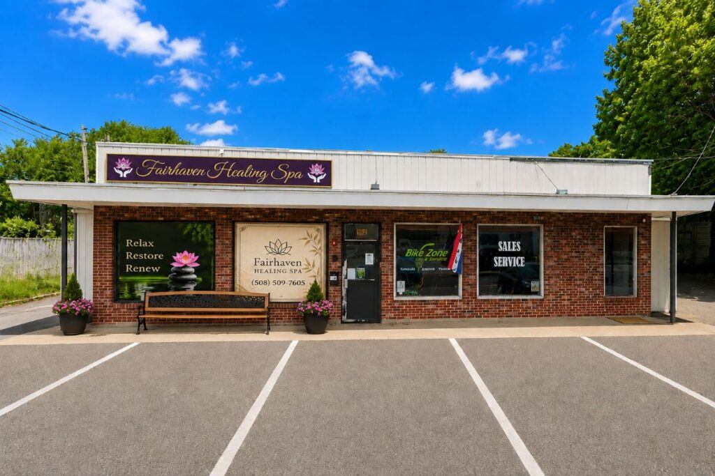 Exterior of Fairhaven Healing Spa in Fairhaven, Massachusetts, featuring spa signage, window displays, bench, and entrance.
